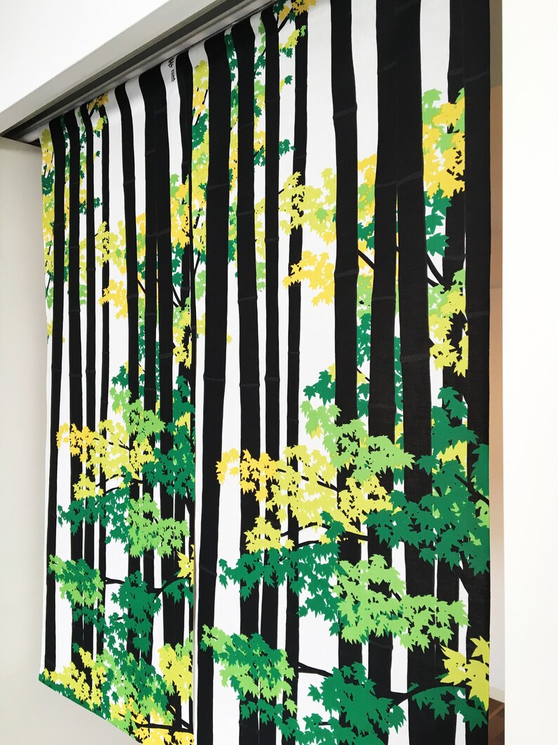May include: Black and white fabric with a repeating pattern of trees and leaves. The leaves are green and yellow.