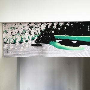 May include: A black and green fabric wall hanging with a white and pink cherry blossom design. The hanging features a Japanese garden scene with a pond, rocks, and a white sand zen garden.