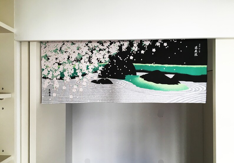 May include: A black and green fabric wall hanging with a white and pink cherry blossom design. The hanging features a Japanese garden scene with a pond, rocks, and a white sand zen garden.