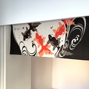 May include: Black and white fabric with a design of red and orange fish swimming in a wave pattern. The fabric is hanging from a white shelf.