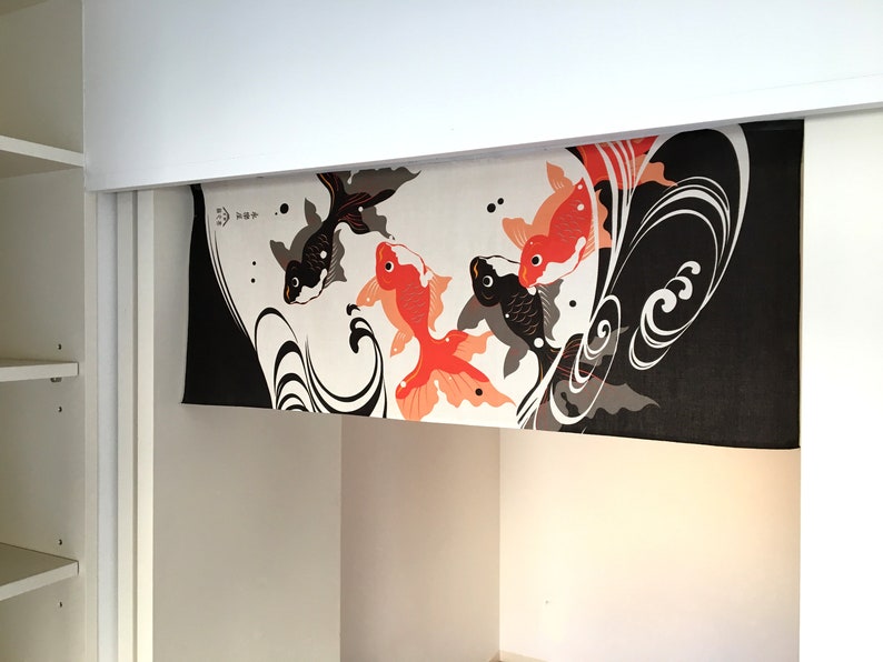 May include: Black and white fabric with a design of red and orange fish swimming in a wave pattern. The fabric is hanging from a white shelf.