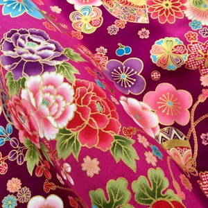 May include: A vibrant pink fabric with a repeating pattern of gold, pink, and purple flowers. The fabric has a textured, almost quilted look.