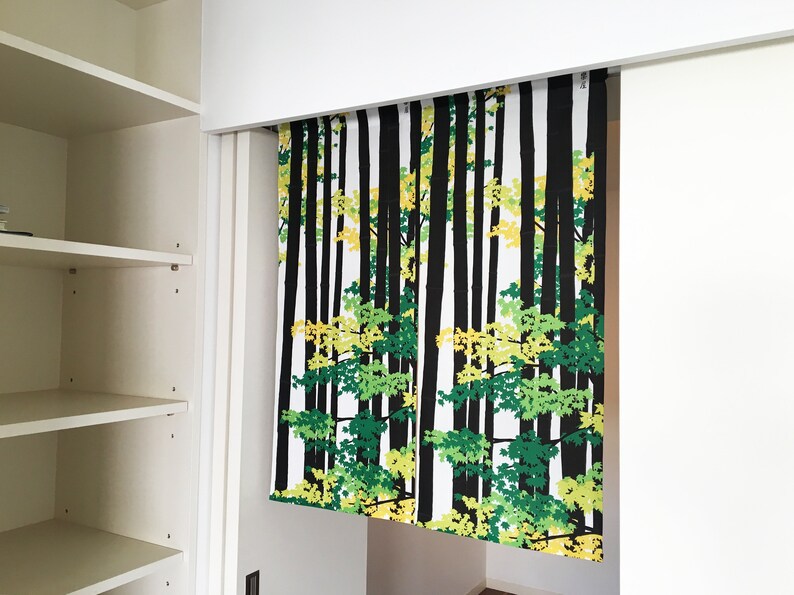 May include: A white curtain with a black and green forest print. The curtain is hanging from a white track.