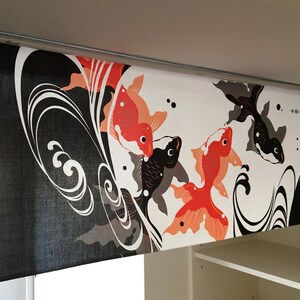 May include: Black and white fabric with a design of red and orange fish swimming in waves. The fabric has the text "幸運" in Japanese characters.