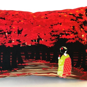 May include: A red and black pillow with a Japanese-inspired design. The pillow features a woman in a traditional kimono standing in a forest of red maple trees.