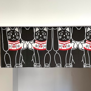 Puede incluir: Cortina Maneki Neko en blanco y negro con cuatro gatos de la suerte estilizados con las patas levantadas. Cada gato tiene un collar rojo con una campana y detalles blancos. La cortina cuelga en una puerta.