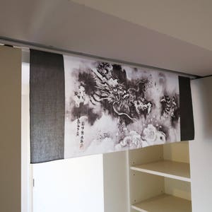 Puede incluir: Panel decorativo de tela con una ilustraci&oacute;n de drag&oacute;n en blanco y negro. Montado sobre una puerta, con una secci&oacute;n de tela negra s&oacute;lida a la izquierda. Se pueden ver caracteres japoneses en el lado derecho.
