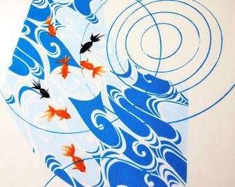 Può includere: Un tessuto bianco con una stampa grafica di pesci rossi arancioni e neri che nuotano tra onde d'acqua blu stilizzate e increspature circolari concentriche. Il design copre la superficie con linee fluide e vivaci immagini acquatiche.