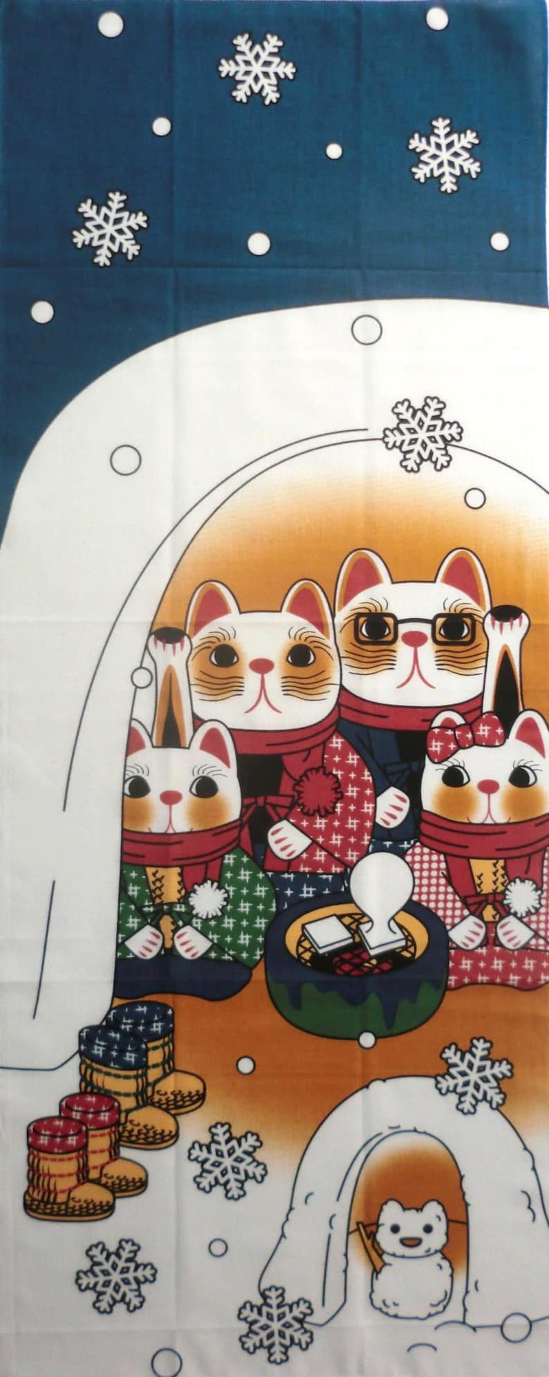 May include: A rectangular fabric panel featuring a winter scene with four cats wearing scarves and patterned clothing gathered around a small dark green brazier. A small white creature sits in an igloo below, with white snowflakes on a blue background.