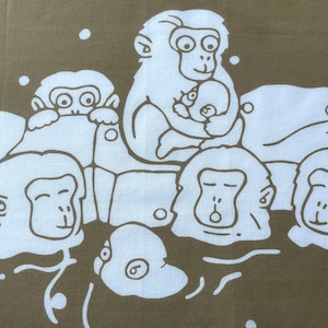 May include: A fabric with a repeating pattern of white monkey illustrations on a muted olive-green background. The monkeys are depicted in various poses, some holding babies, creating a playful design.