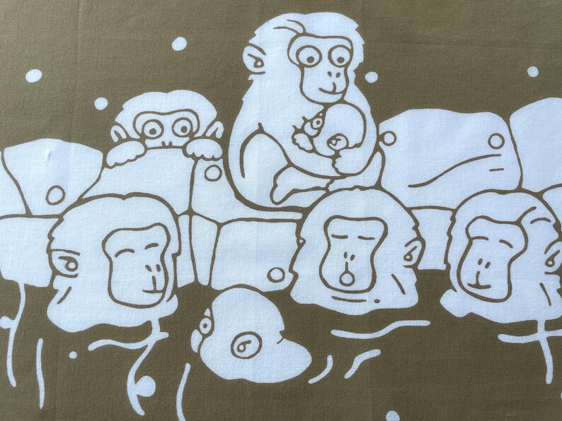 May include: A fabric with a repeating pattern of white monkey illustrations on a muted olive-green background. The monkeys are depicted in various poses, some holding babies, creating a playful design.