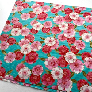 May include: Teal fabric with a repeating pattern of pink and red flowers with gold accents. The fabric has a subtle striped texture.
