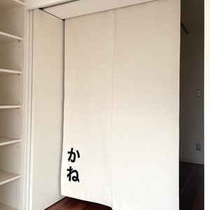 Puede incluir: Puertas corredizas blancas con la palabra japonesa "kana" escrita en negro en la puerta de la izquierda.