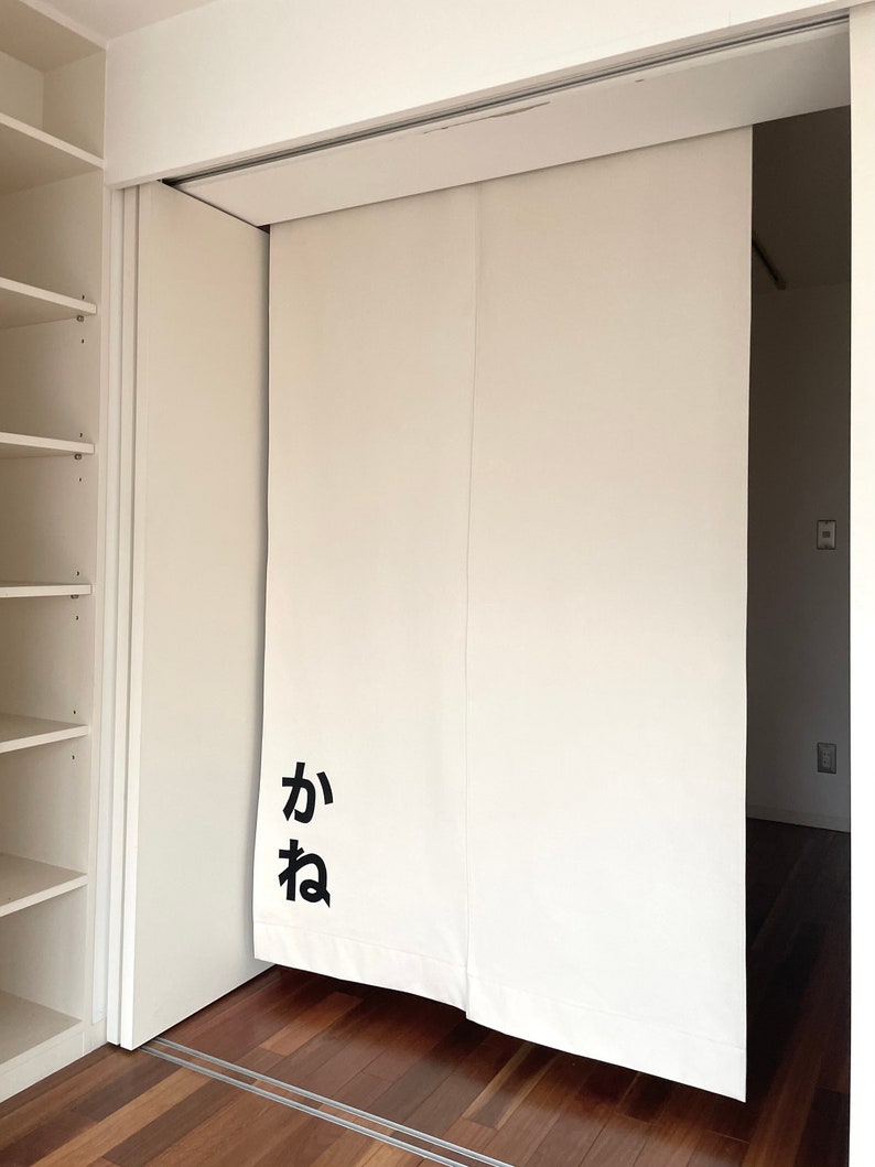 Puede incluir: Puertas corredizas blancas con la palabra japonesa "kana" escrita en negro en la puerta de la izquierda.