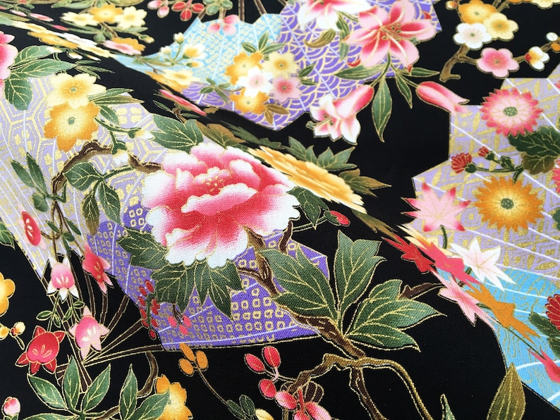 Puede incluir: Tela negra con un patr&oacute;n floral con flores rosas, amarillas y blancas con detalles dorados. La tela tiene un dise&ntilde;o de inspiraci&oacute;n japonesa con formas geom&eacute;tricas y detalles intrincados.
