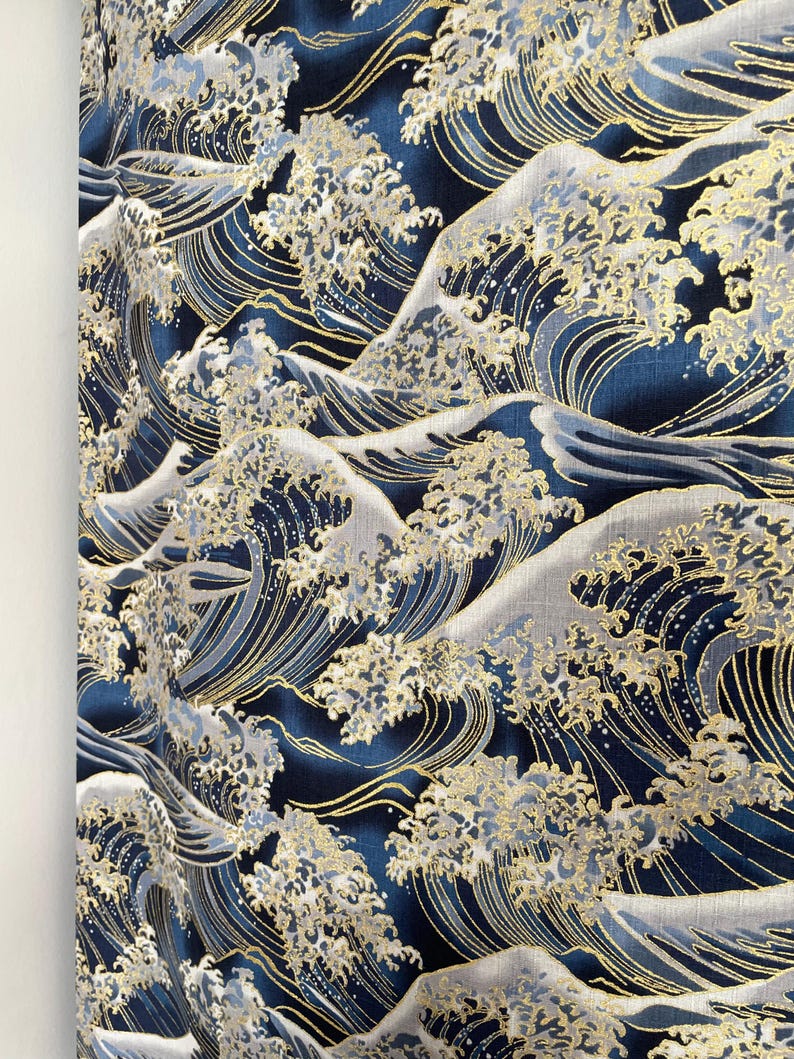 May include: A navy blue fabric with a repeating pattern of gold and white waves. The waves are stylized and resemble the Great Wave off Kanagawa.