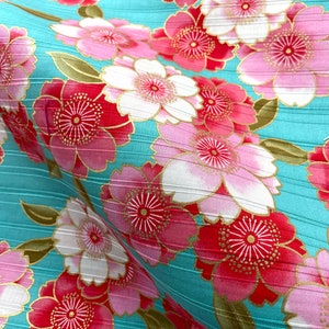 May include: A turquoise fabric with a repeating pattern of pink and red flowers with gold accents. The fabric has a subtle striped texture.