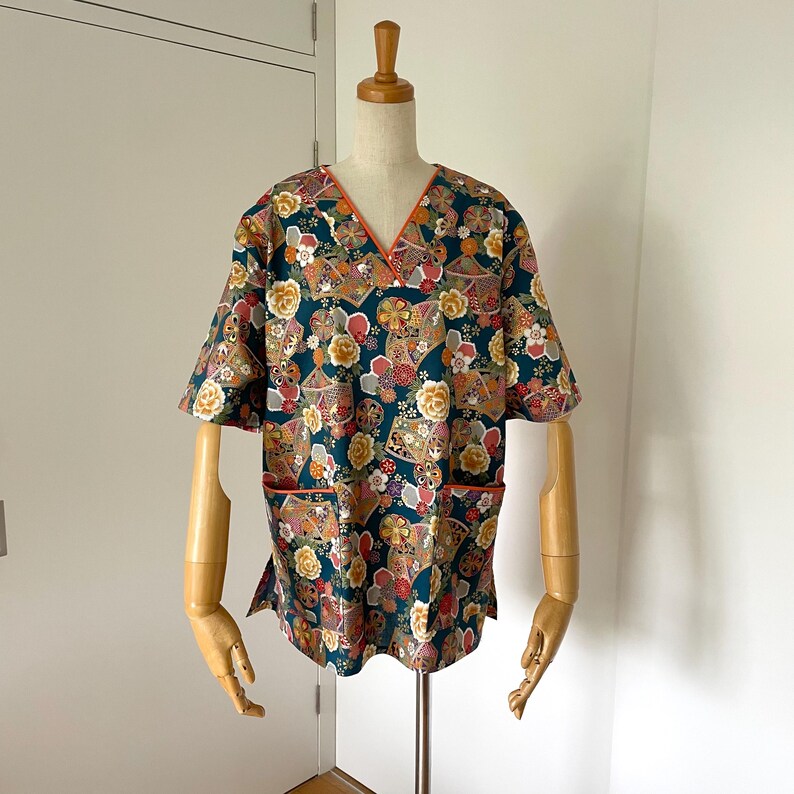 Uniforme médico femenino con cuello en V y dos bolsillos, confeccionado a medida para profesionales de la salud. Blusa médica japonesa de tela floral verde. Tallas de la XS a la XXL. imagen 1