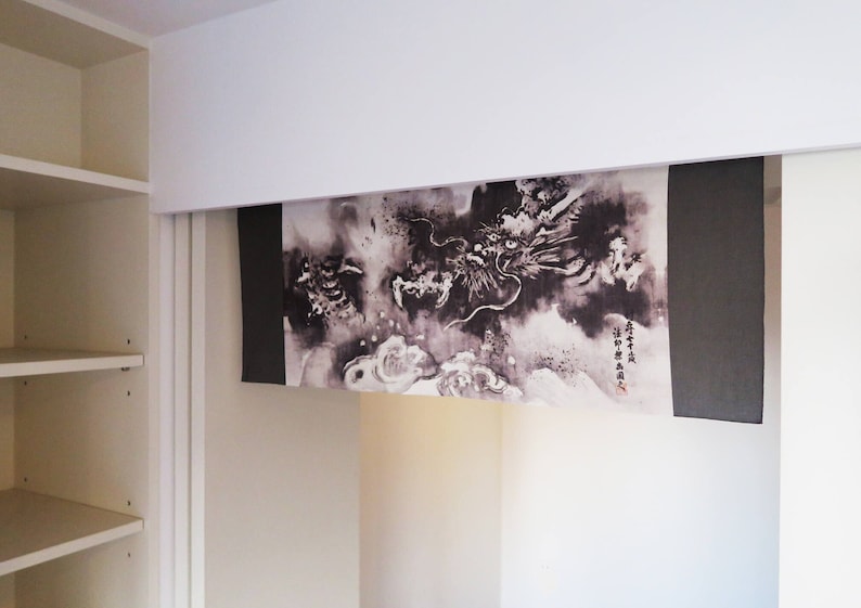 Puede incluir: Un tapiz mural japon&eacute;s en blanco y negro con un dise&ntilde;o de drag&oacute;n. La obra de arte est&aacute; enmarcada por paneles grises oscuros. El drag&oacute;n se representa en una pose din&aacute;mica en medio de nubes y patrones arremolinados. Se ve algo de texto japon&eacute;s.