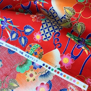 May include: Red cotton fabric with a Japanese-inspired print featuring flowers, leaves, and geometric patterns. The fabric has a label that reads "Made in Japan Cotton 100% 神様 紅型プリント".