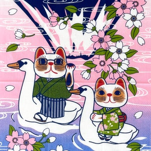 May include: A fabric print featuring two cats wearing green kimonos riding white swans on a blue and pink water background. The scene is decorated with pink cherry blossoms and white petals, with one cat wearing glasses and waving a paw.