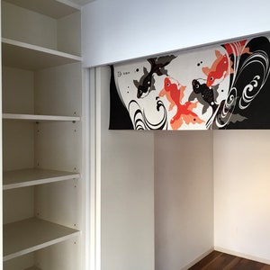 May include: White closet with four shelves and a sliding door. The door is open and reveals a white alcove with a decorative fabric panel featuring black and orange fish designs. The panel has the text "33" in black.