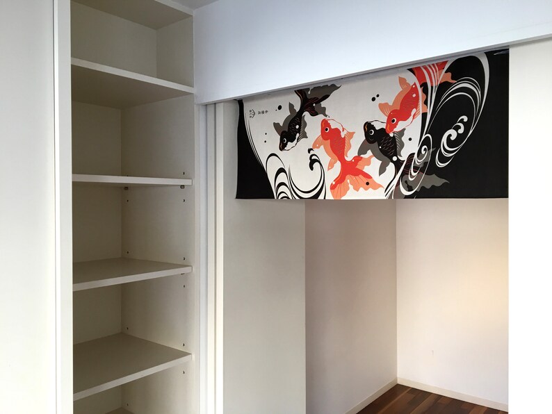 May include: White closet with four shelves and a sliding door. The door is open and reveals a white alcove with a decorative fabric panel featuring black and orange fish designs. The panel has the text "33" in black.