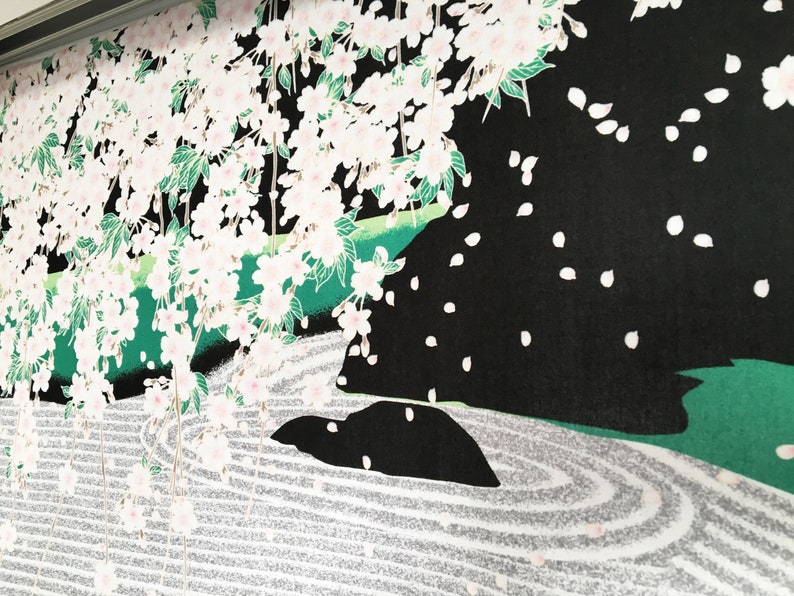 May include: A black and white illustration of a Japanese garden featuring a cherry blossom tree, a rock formation, and a white sand zen garden.