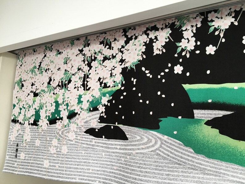 May include: A black fabric panel featuring a Japanese garden design. The panel depicts a white cherry blossom tree with pink flowers, a green pond with a rock, and a white sand garden with a circular pattern.