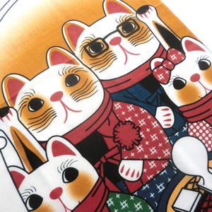 May include: A fabric print featuring four stylized white cats with orange markings, wearing red scarves and patterned winter clothing. One cat wears black-rimmed glasses, another has a red bow, and a snowflake icon is visible at the top.