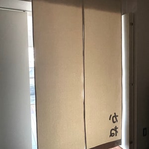 Puede incluir: Dos separadores de ambientes de tela beige con un car&aacute;cter japon&eacute;s impreso en el panel derecho.