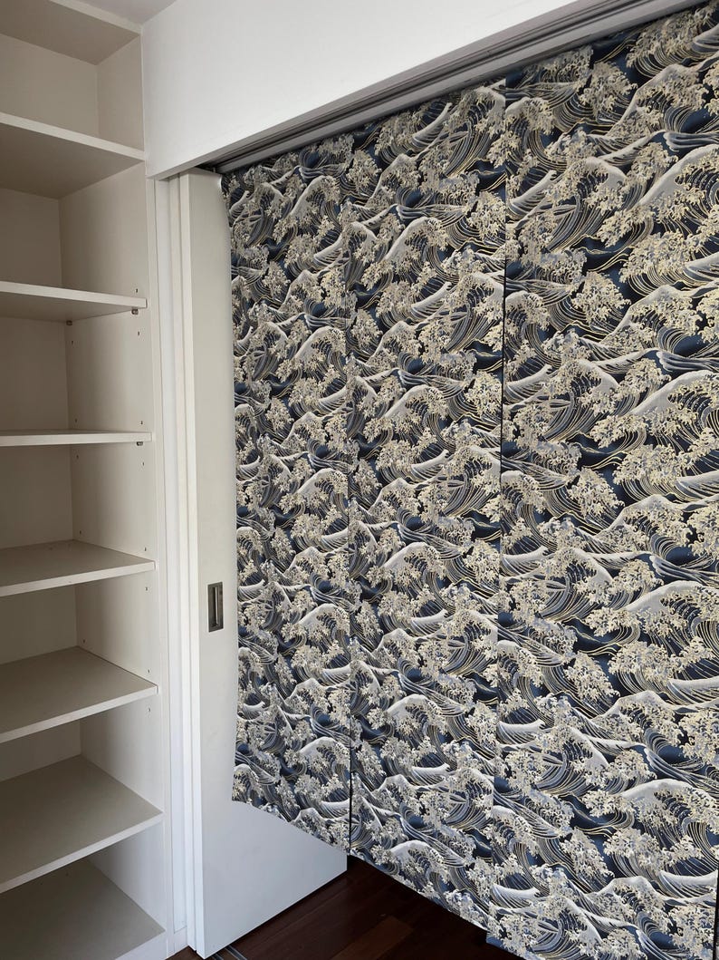 May include: A set of sliding closet doors with a wave pattern in shades of blue and gold. The doors are made of fabric and have a traditional Japanese design.