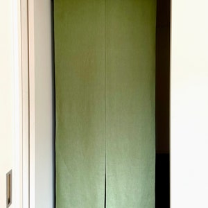 Puede incluir: Un par de divisores de habitaci&oacute;n de tela verde colgados en una puerta. Los divisores est&aacute;n hechos de una tela texturizada y tienen un brillo sutil.