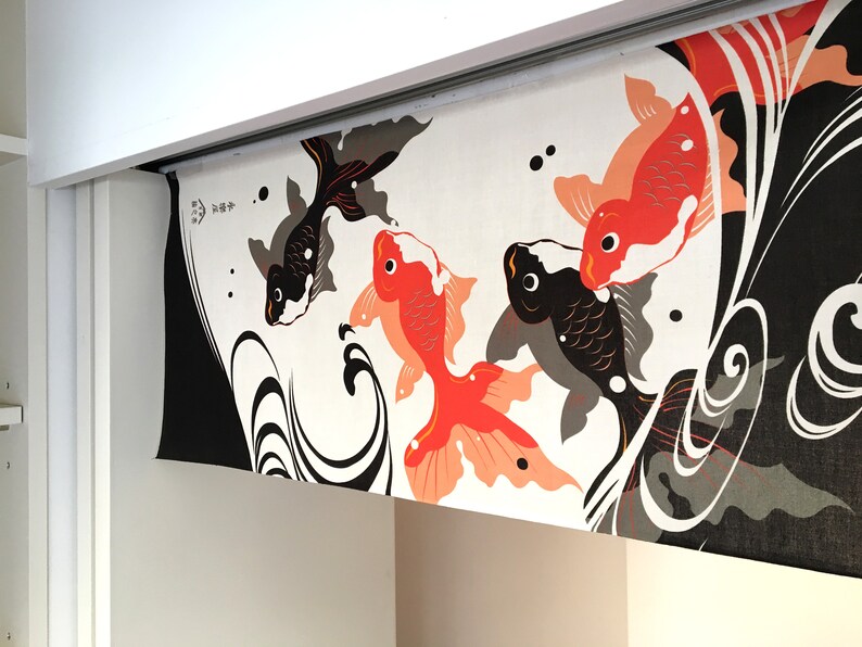 May include: A white fabric panel with a black and red Japanese-style design featuring four stylized fish, two black and two red, swimming in a swirling pattern. The panel has the text "魚々" in black.