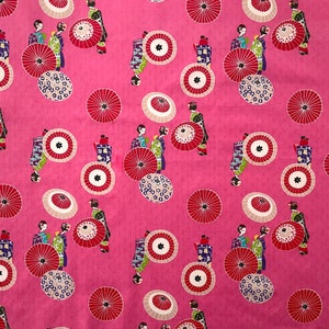 May include: Pink fabric with a repeating pattern of geishas in traditional clothing, holding fans and parasols. The pattern also includes stylized flowers and circles.