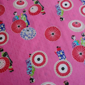 May include: Pink fabric with a repeating pattern of geishas, umbrellas, and flowers. The umbrellas are red, white, and black. The geishas are wearing traditional Japanese clothing.