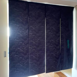 May include: A set of four dark blue fabric panels with a subtle wave pattern. The panels are hanging from a track and are partially open, revealing a wooden floor.