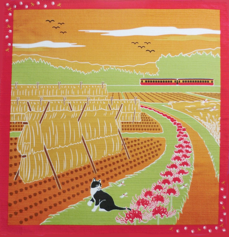 May include: A black and white cat sits in a field of red spider lilies. In the background, there are bundles of hay, a train, and a green hillside. The sky is a pale yellow with a few white clouds.