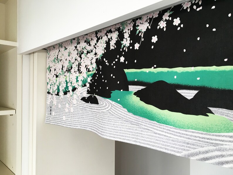 May include: A black and white fabric panel with a Japanese garden design. The panel features a green river, white sand, and a cherry blossom tree with pink flowers.