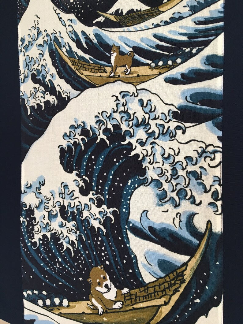 May include: A blue and white wave design with two Shiba Inu dogs riding in wooden boats. The wave is a stylized version of the Great Wave off Kanagawa, a famous Japanese woodblock print.