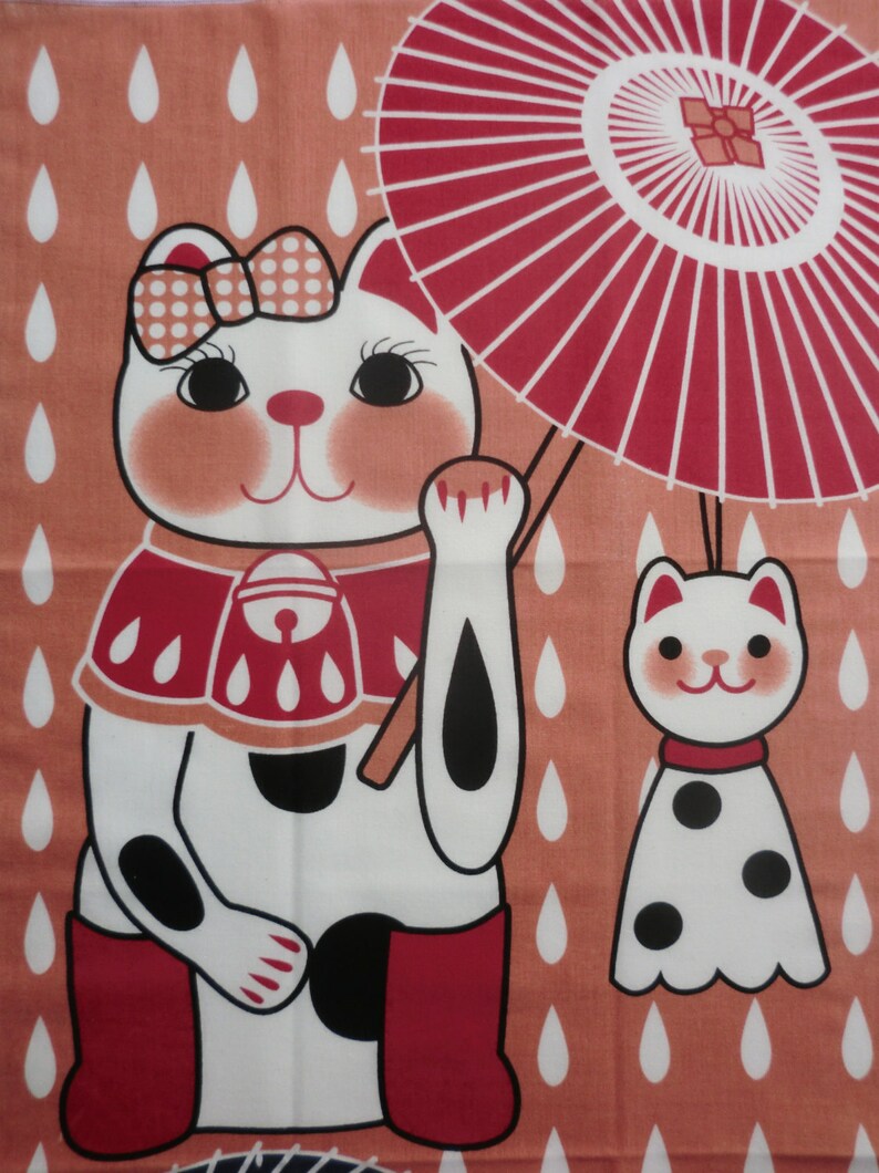 May include: A white cat with black spots and red boots holds a red and white umbrella. The cat is wearing a red and white bib with a bell. The background is a peach color with white raindrops. A smaller white cat with black spots is standing to the right of the larger cat.