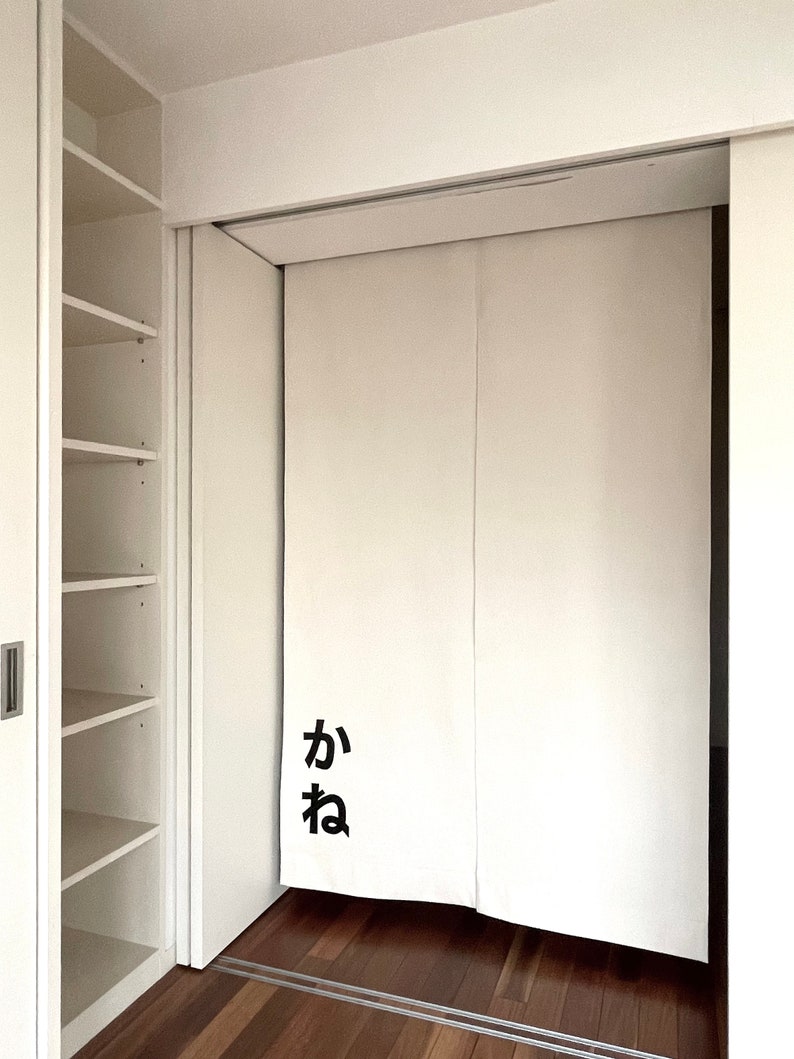Puede incluir: Puertas corredizas blancas con un car&aacute;cter japon&eacute;s negro "か" en la puerta izquierda. Las puertas est&aacute;n cerradas y la habitaci&oacute;n detr&aacute;s de ellas no es visible.