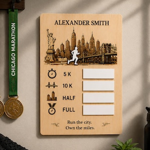 May include: A wooden marathon medal display board featuring the name "ALEXANDER SMITH". The design includes a cityscape, a runner silhouette, and spaces for race distances: 5K, 10K, Half, and Full. The text "Run the city. Own the miles." is at the bottom.