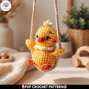 Puede incluir: Un pollito de ganchillo amarillo con patas naranjas y un cuello blanco, suspendido en un columpio de cuerda beige trenzada. El pollito tiene ojos oscuros, un pequeño pico naranja y un mechón de plumas en la cabeza. El texto inferior dice PDF CROCHET PATTERN.