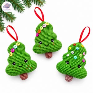 Puede incluir: Tres adornos de árbol de Navidad de ganchillo verde con troncos marrones y lazos de cinta roja para colgar. Cada árbol presenta ojos negros bordados, una pequeña sonrisa y botones de plástico de colores unidos a la superficie como decoración.