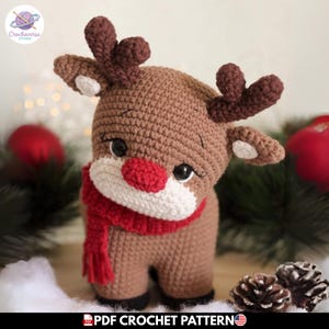 Puede incluir: Un juguete de peluche de reno tejido a ganchillo en color marrón con una nariz roja brillante, un hocico blanco y una bufanda roja tejida. El reno tiene astas de color marrón oscuro, ojos negros con pestañas y orejas blancas. El texto dice PDF CROCHET PATTERN.