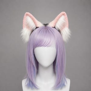 May include: A headband featuring plush, upright animal ears with soft pink outer edges and white faux fur interiors. The ears are attached to a dark band, displayed on a mannequin head with straight, shoulder-length lavender hair.
