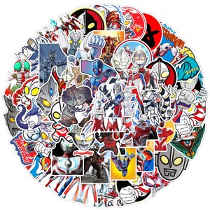 Puede incluir: Una gran colecci&oacute;n de pegatinas circulares y troqueladas con varios personajes de Ultraman en tonos rojo, plata y azul. Las pegatinas muestran diversas poses, escenas de acci&oacute;n y retratos de los h&eacute;roes, incluyendo texto en japon&eacute;s y la palabra ZERO.