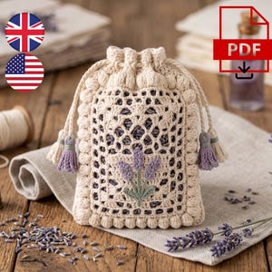 May include: A cream-colored crochet drawstring pouch featuring a lattice pattern and a central lavender flower embroidery. The bag is finished with a bobble-stitch border and two matching tassels with light purple accents at the drawstring ends.