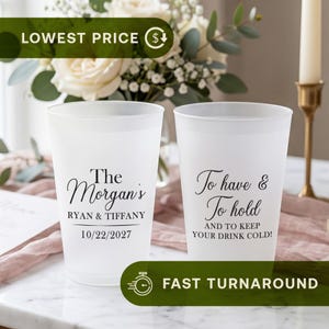 May include: Two frosted plastic cups featuring black printed text. The left cup displays The Morgan's, RYAN & TIFFANY, and 10/22/2027. The right cup displays To have & To hold AND TO KEEP YOUR DRINK COLD! The cups have a smooth, translucent finish.
